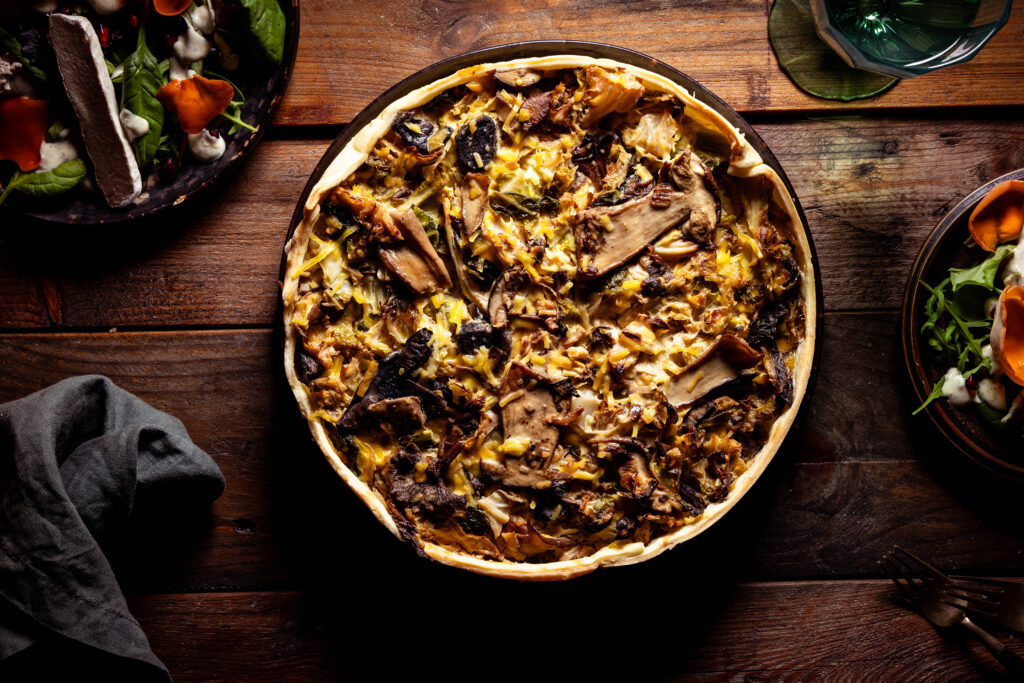 Waldpilz-Wirsing-Quiche von oben auf einem alten Holztisch