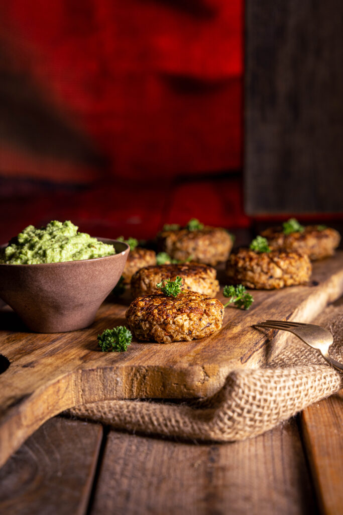 Zero Waste Bouletten - aus Bratensaucentrester - auf einem Holzbrett mit einer Schale grünem Dip.