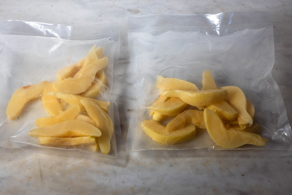 Quittenschnitze fermentieren in aufgeblähten Vakuumierbeuteln.