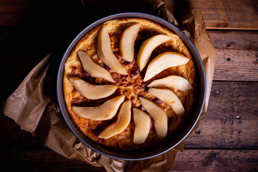 Quittenschnitze auf einem Käsekuchen verteilt.