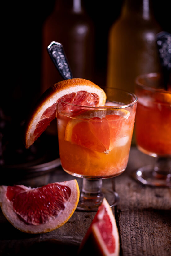 Grapefruit-Kombucha mit Eiswürfeln und frischer Grapefruit.