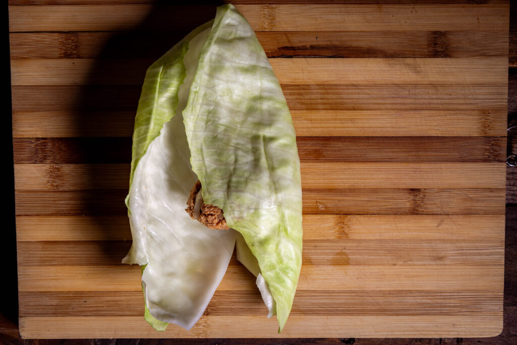 Vegane Kohlrouladen werden gefüllt und gerollt.
