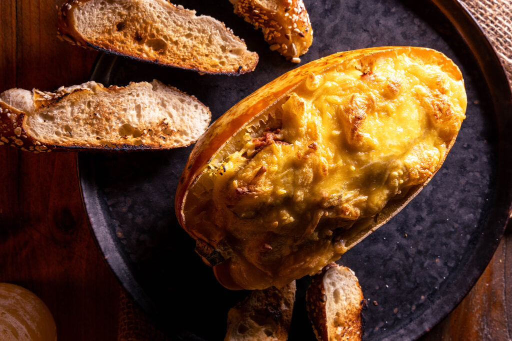 Überbackener Spaghettikürbis mit Pulled-Jackfruit-Pilz-Ragout, deneben geröstetes Brot