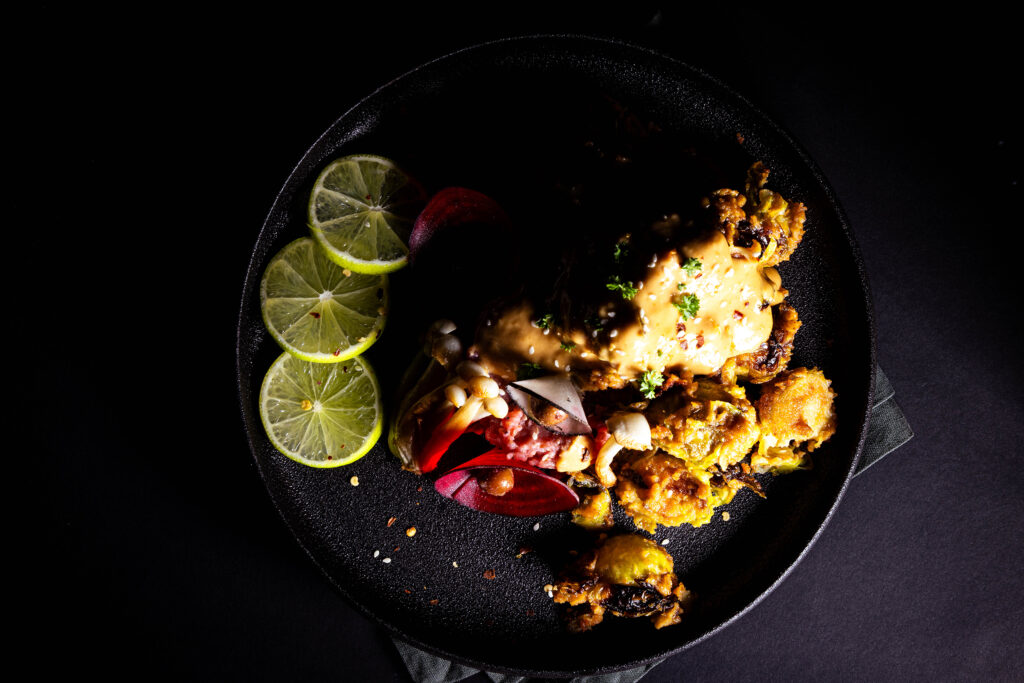 Roasted Brussels sprouts deep-fried in peanut sauce on a plate.