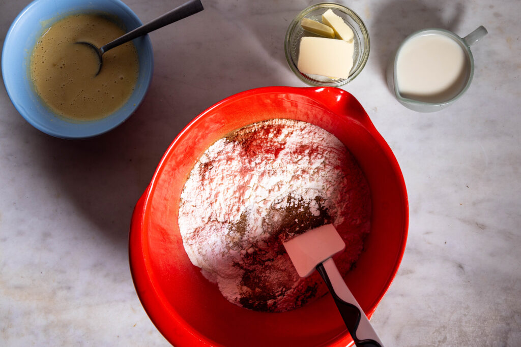 Mehl, Zucker, Backpulver, Natron und Zimt werden in einer Rührschüssel vermengt.