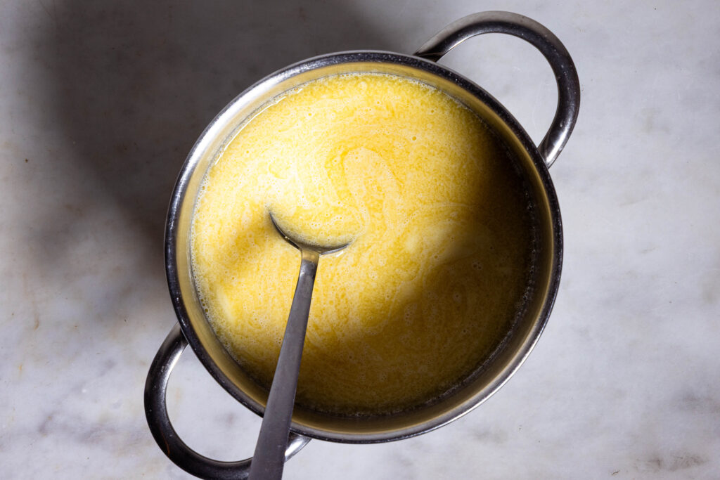 Ein kleiner Topf mit veganer Butter, Sojamilch und angerührtem Kichererbsenmehl.