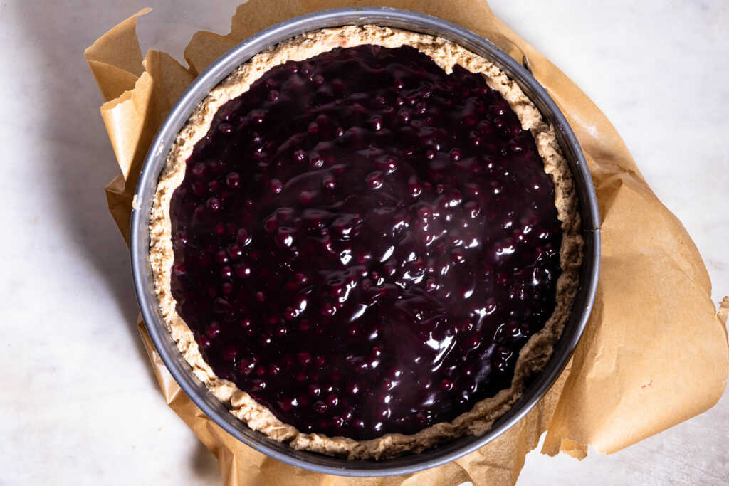 Blaubeerfüllung wird auch einem Kuchenboden verteilt.