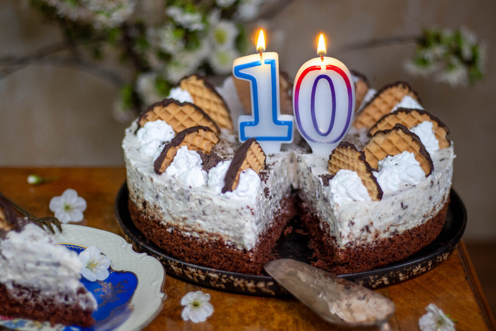 Eine 10 in Form von brennenden Geburtstagkerzen auf einer Schokokusstorte.