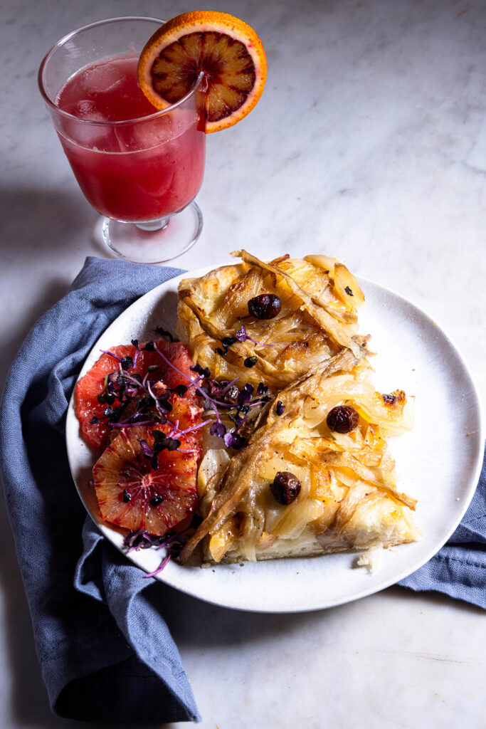 Pissaladière – französische Sardellen-Zwiebeltarte mit einem Glas Blutorangensaft