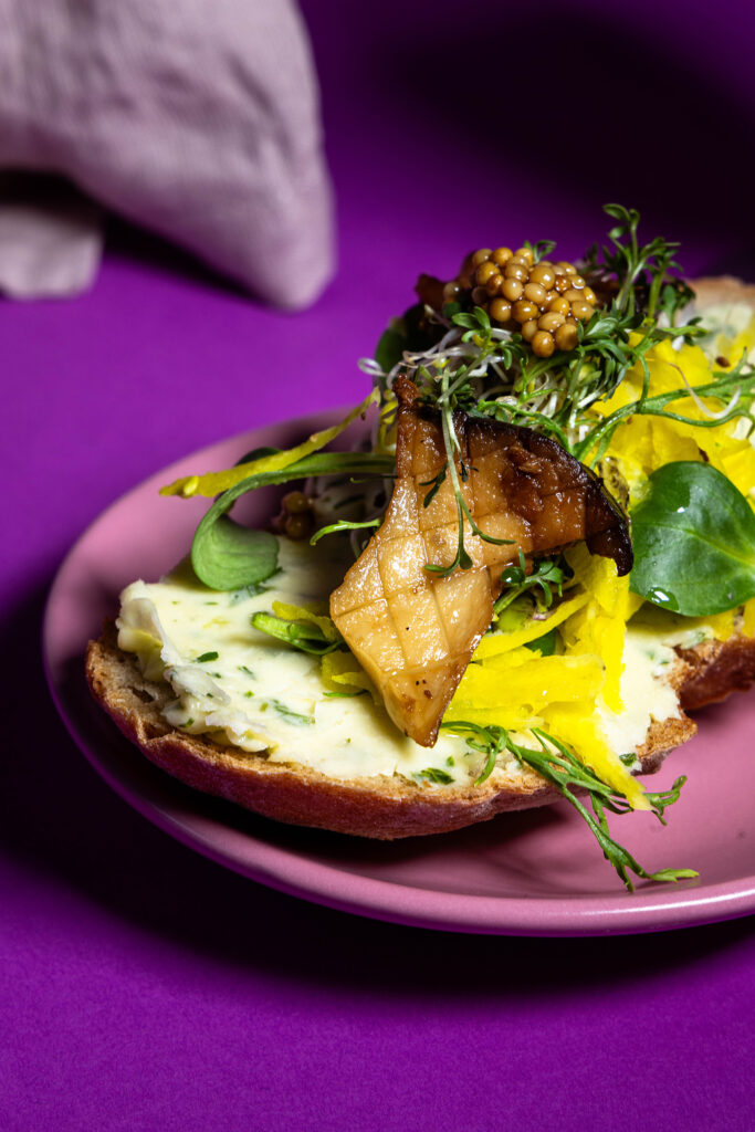 Blattsenfbutter auf einem reichlich belegten Brot