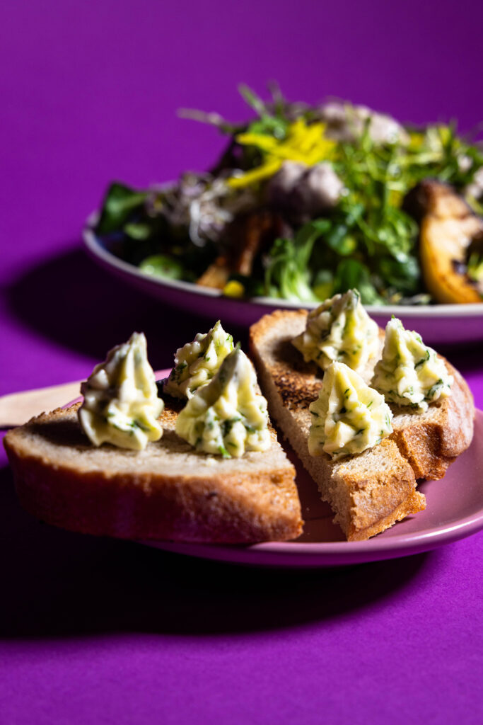 Blattsenfbutter, als Rosetten auf eine Scheibe geröstetes Brot gespritzt