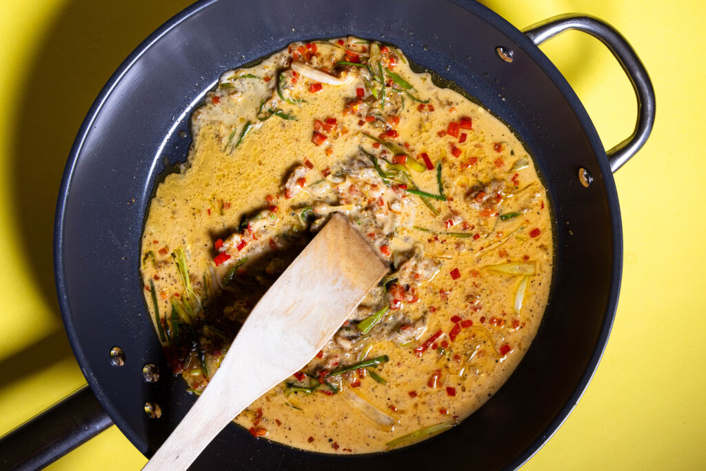 Eine Chilisauce wird in einer Pfanne zubereitet.