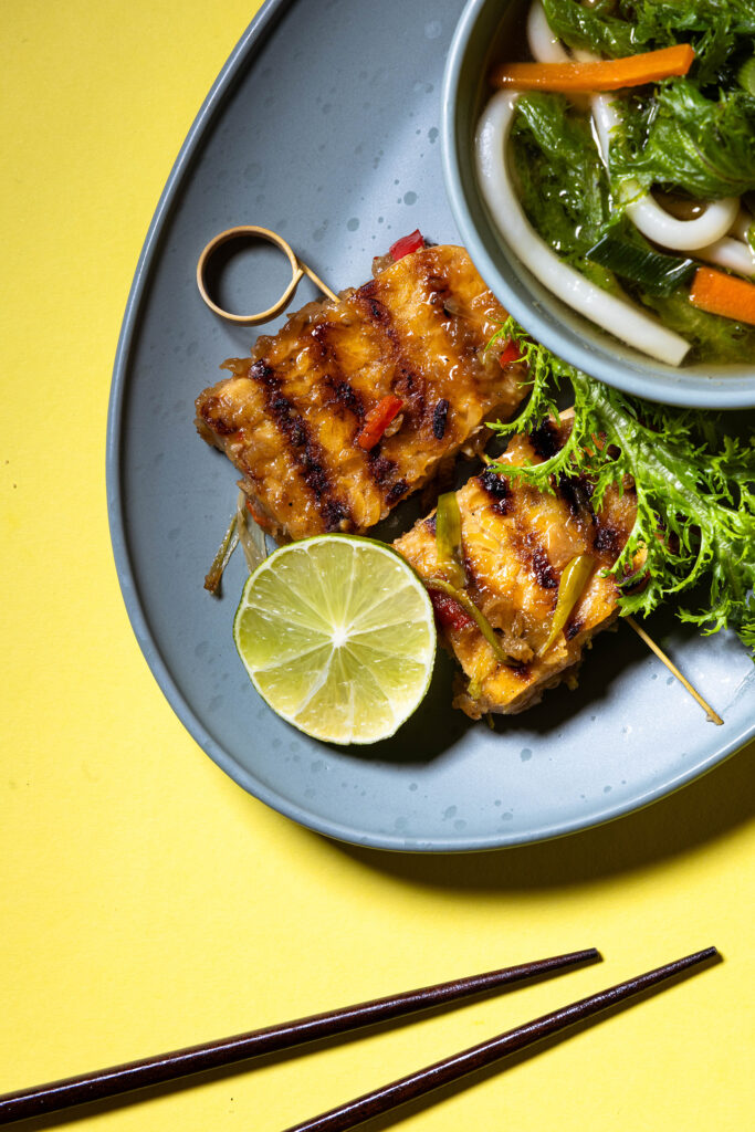 Doppelt gegrillter Tempeh - gebraten in Chilisauce - auf einem Spieß als Beilage