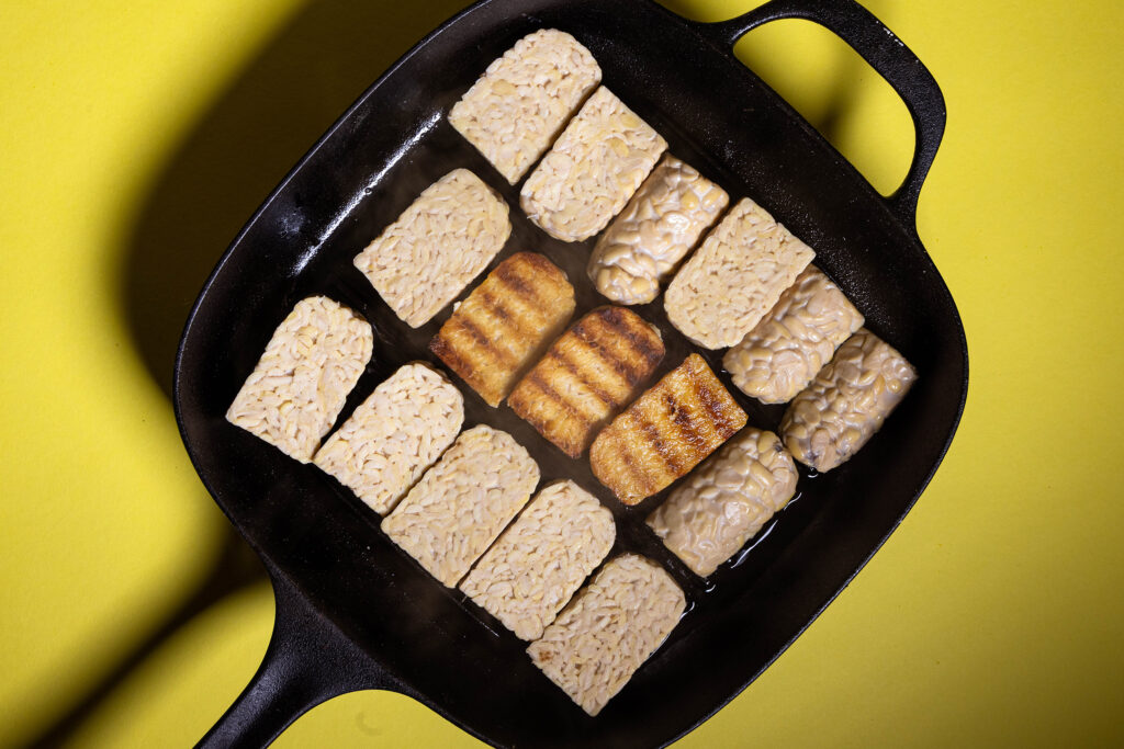 Tempehscheiben werden in einer Grillpfanne angebraten.