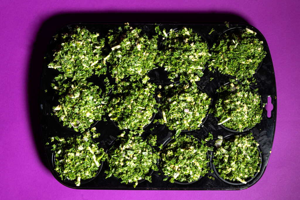 Rohe Grünkohl-Cupcakes in einem Muffinblech.