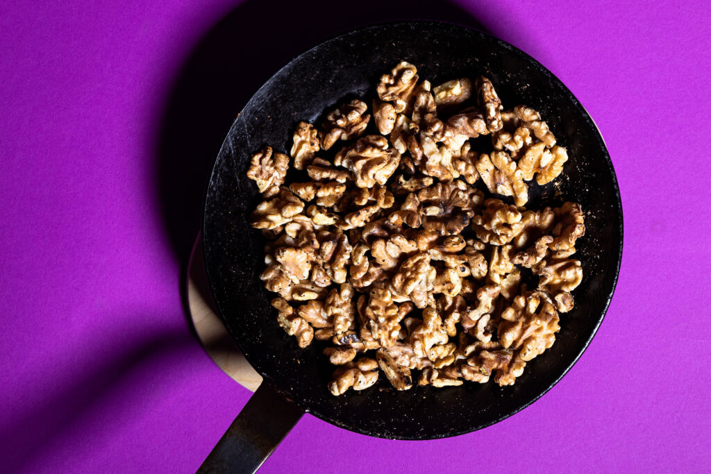 Walnüsse werden in einer Pfanne ohne Fett angeröstet.