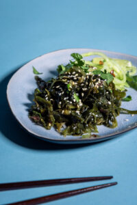 Wakame-Salat - japanischer Salat aus Algen auf einem blauen Teller