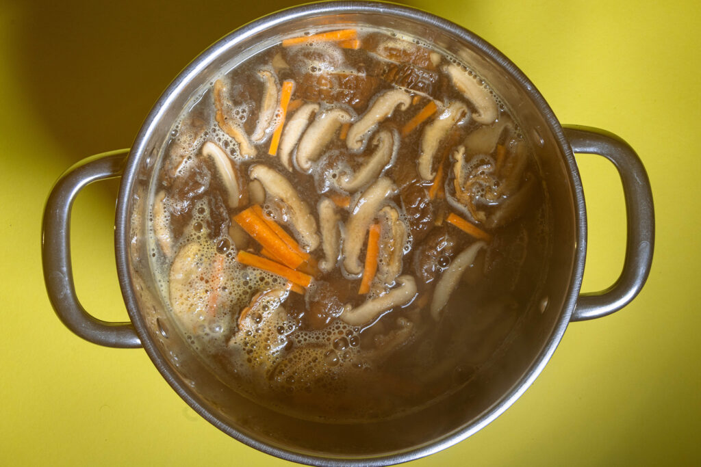 Miso-Suppe mit Shitake und Karotte in einem Topf.