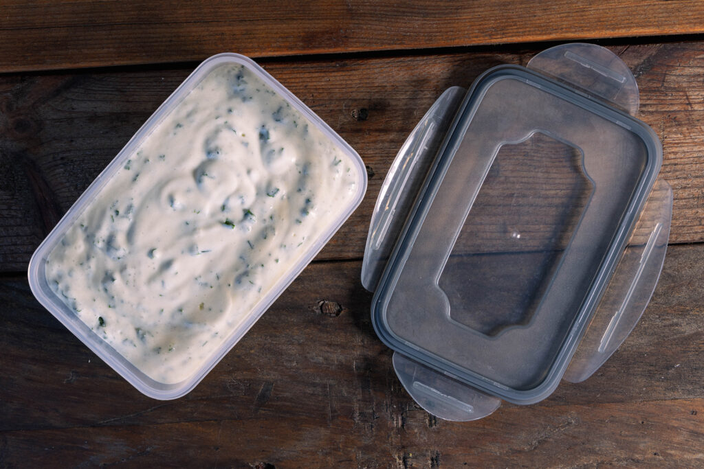 Frisch angerührter Bärlauch-Vrischkäse in einer Tupperdose.