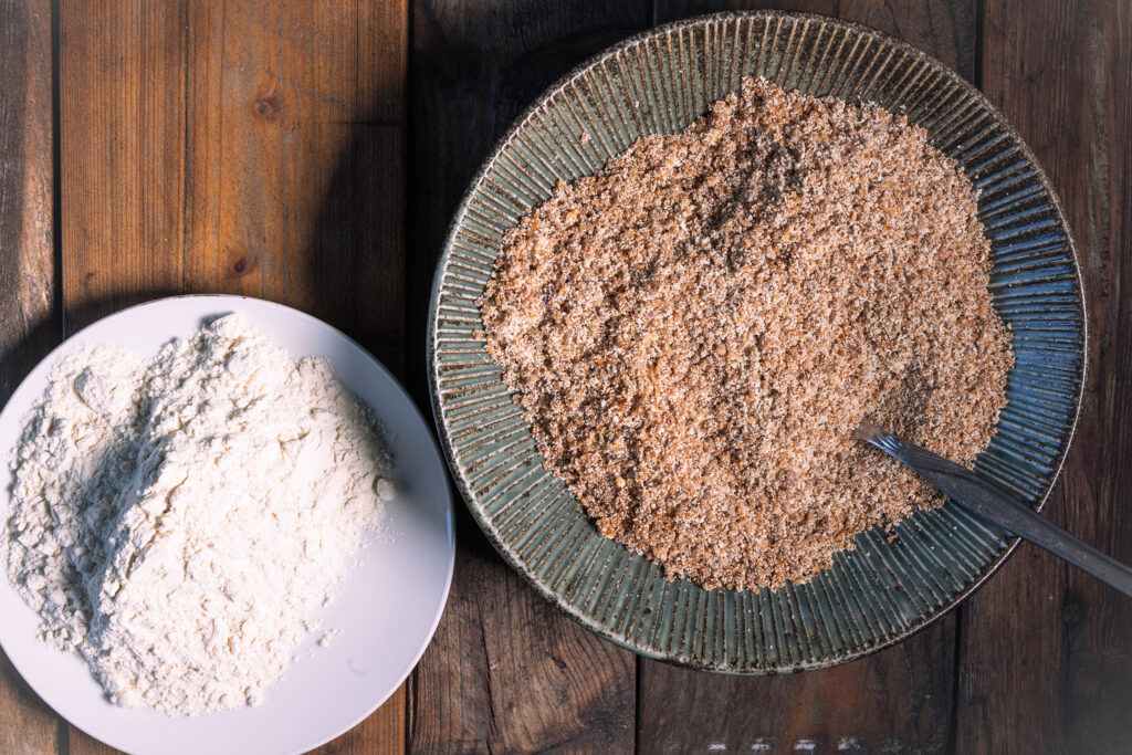 Ein Teller mit Mehl und eine Schale mit einer Mischung aus Paniermehl und Röstzwiebeln.