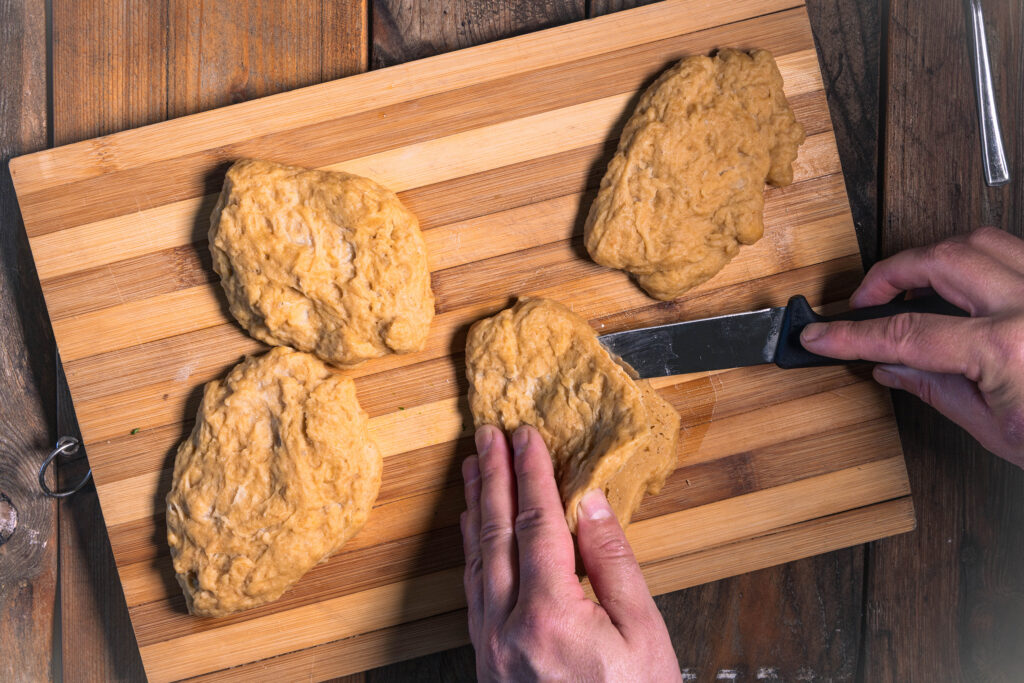 Seitanschnitzel werden aufgeschnitten, so dass man sie mit Bärlauch füllen kann.