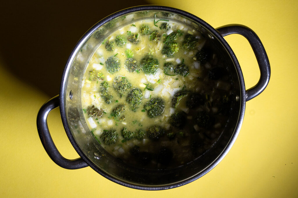 Brokkoli Curry Cremesuppe wird in einem Kochtopf zubereitet.