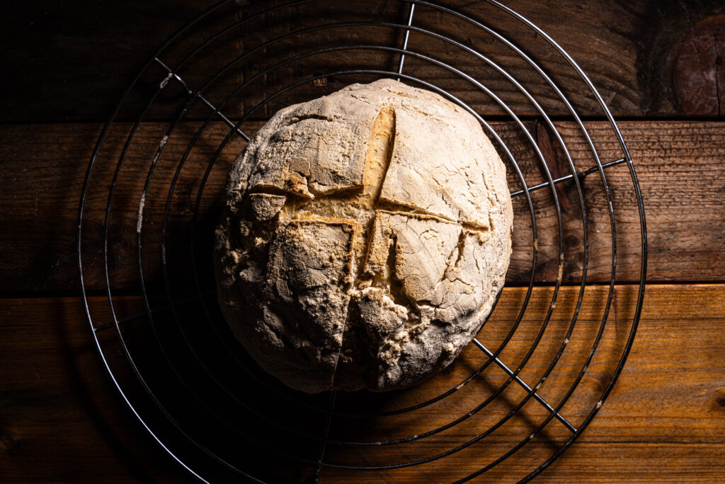 Ein frisch gebackenes Kefirbrot kühl auf einem Rost aus.