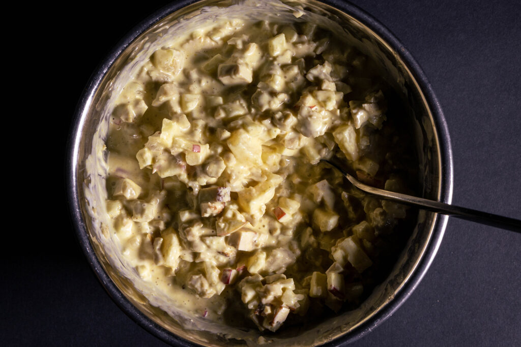 Curry-Geflügelsalat wird in einer Schüssel zubereitet.