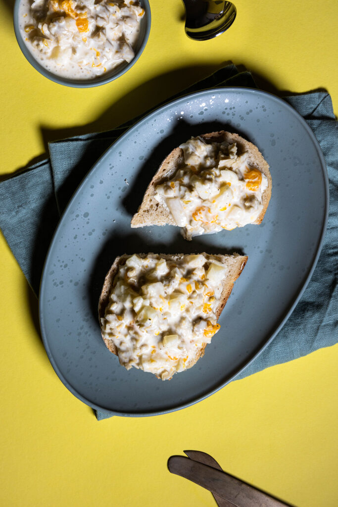 GeVlügelsalat mit Ananas und Mandarine - ein kulinarisches Zeitportal direkt in die 80erauf einem Brot und in einer Schale.