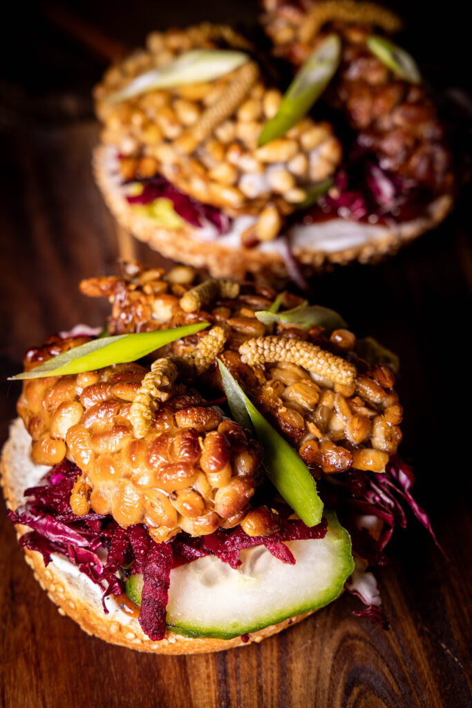 Haselkätzchen-Pickles auf einem Sandwich mit selbstgemachtem, geräucherten Tempeh