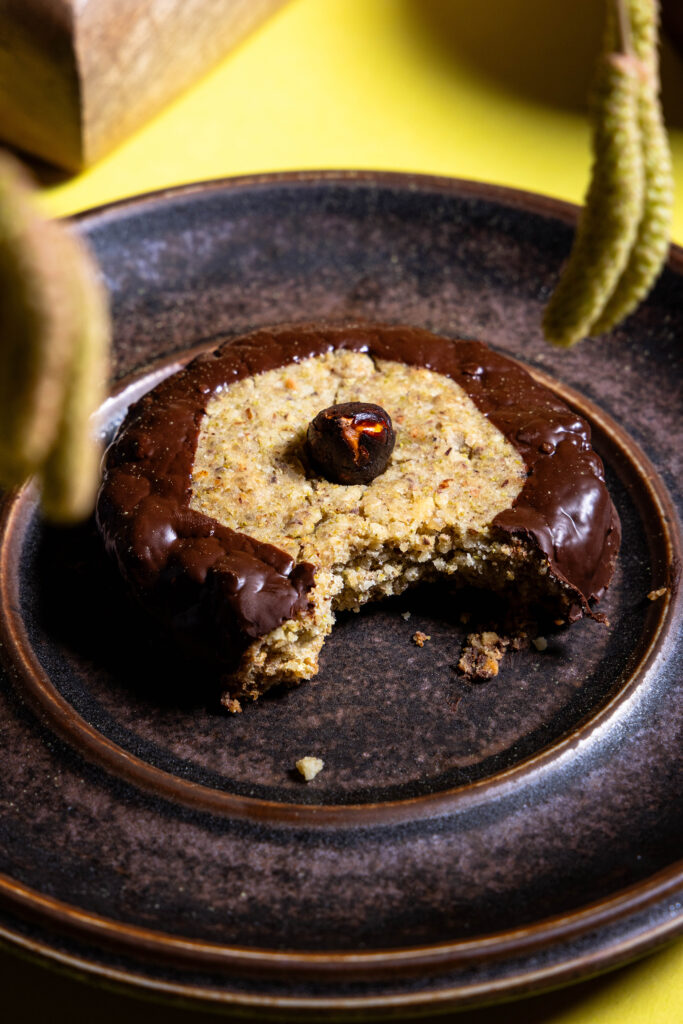 Ein Haselkätzchenplätzchen angebissen auf einem Teller