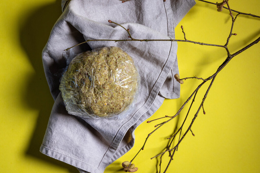 Haselnussplätzchenteig mit Haselkätzchenmehl in Frischhaltefolie gewickelt.