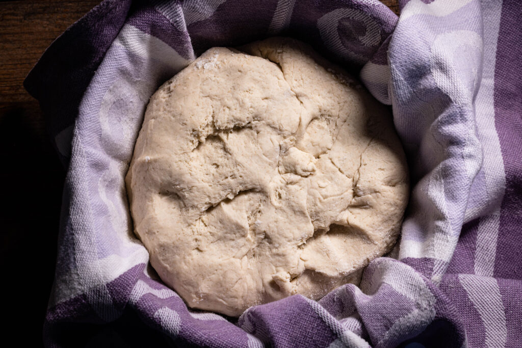 Kefir-Roggenbrottei in einer mit einem Küchentuch ausgelegten, bemehlten Schüssel.