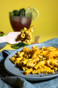 Maccaroni and Cheese - vegan und selbstgemacht auf einem Teller und auf eine Gabel gespickt.