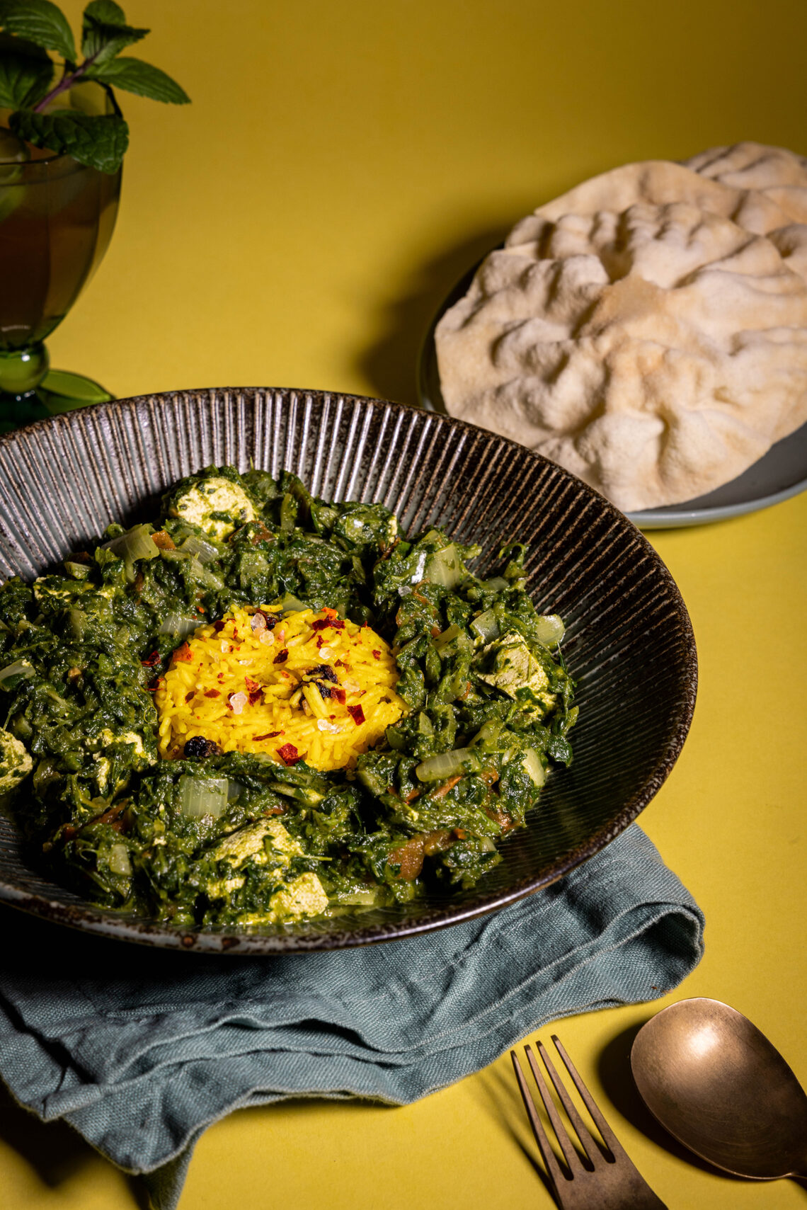 Palak Paneer - mit veganem, indischen Paneer-Käse - in einer Bowl, dazu Papadam