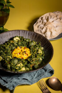 Palak Paneer - mit veganem, indischen Paneer-Käse - in einer Bowl, dazu Papadam