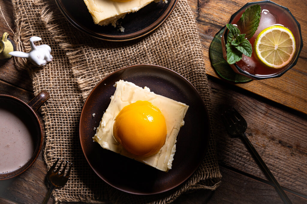 Veganer Pfirsich-Käsekuchen - bäuerlich, rustikal, wie von Oma, auf einem alten Holztisch.