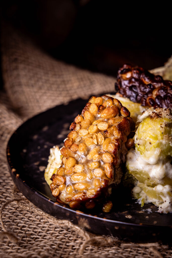 Räuchertempeh, angebraten, auf gratiniertem Rosenkohl