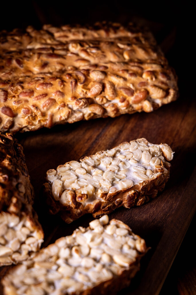 Geräucherter Tempeh angeschnitten auf einem Holzbrett