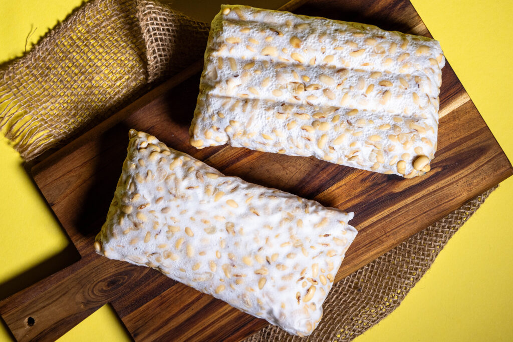 Selbstgemachter Tempeh, zwei frische Blöcke auf einem Holzbrett