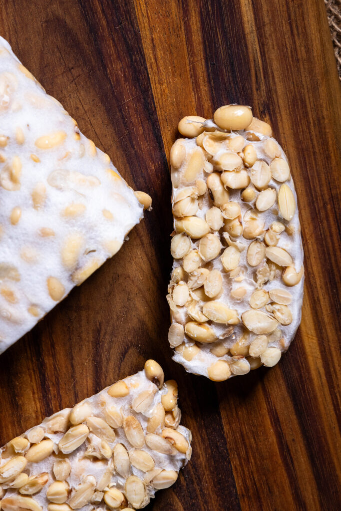 Frsicher, selbstgemachter Tempeh, angeschnitten auf einem Holzbrett.