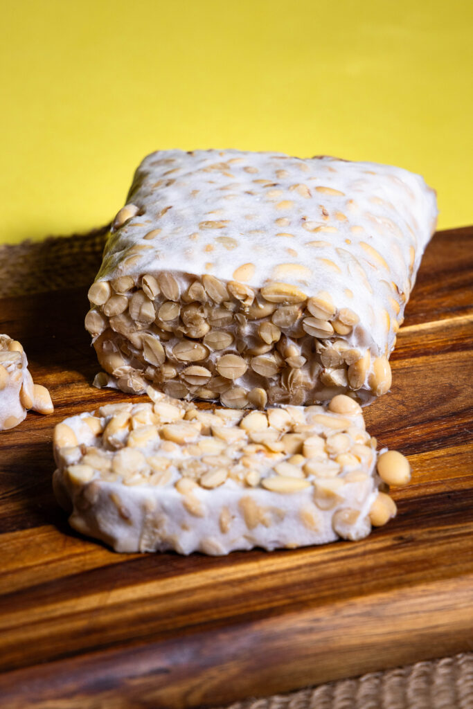 Frsicher, selbstgemachter Tempeh, angeschnitten auf einem Holzbrett.