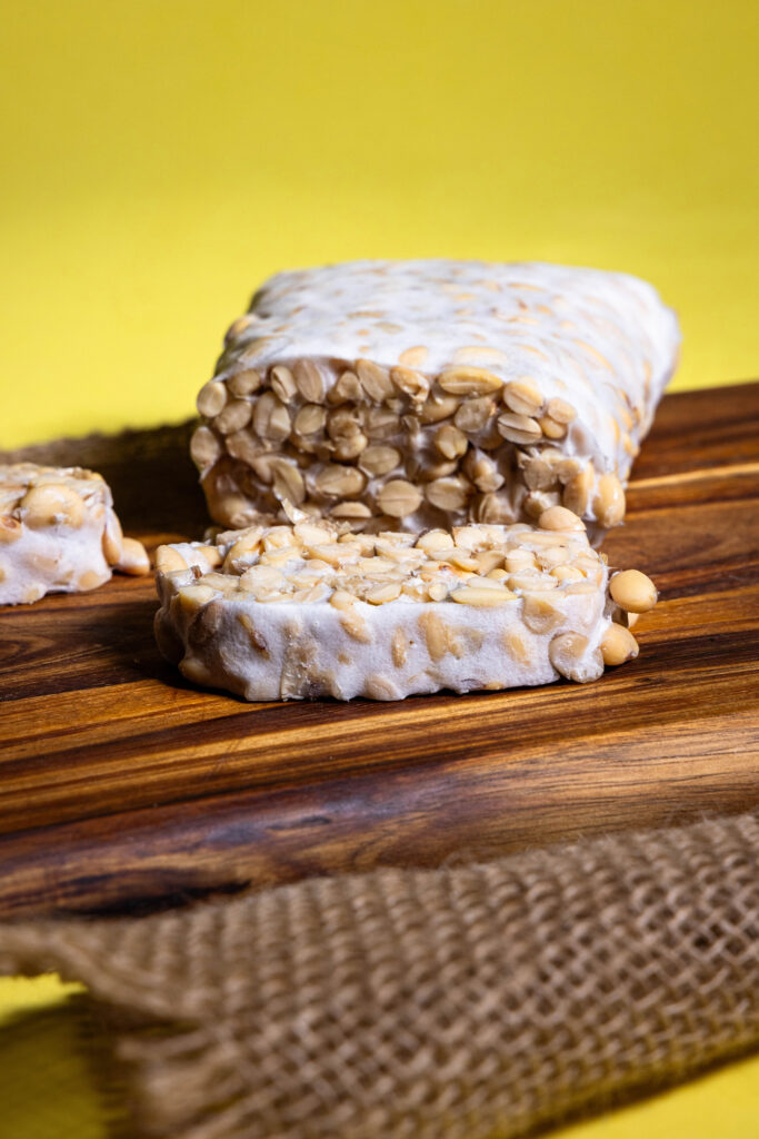 Selbstgemachter Tempeh, angeschintten auf einem Holzbrett