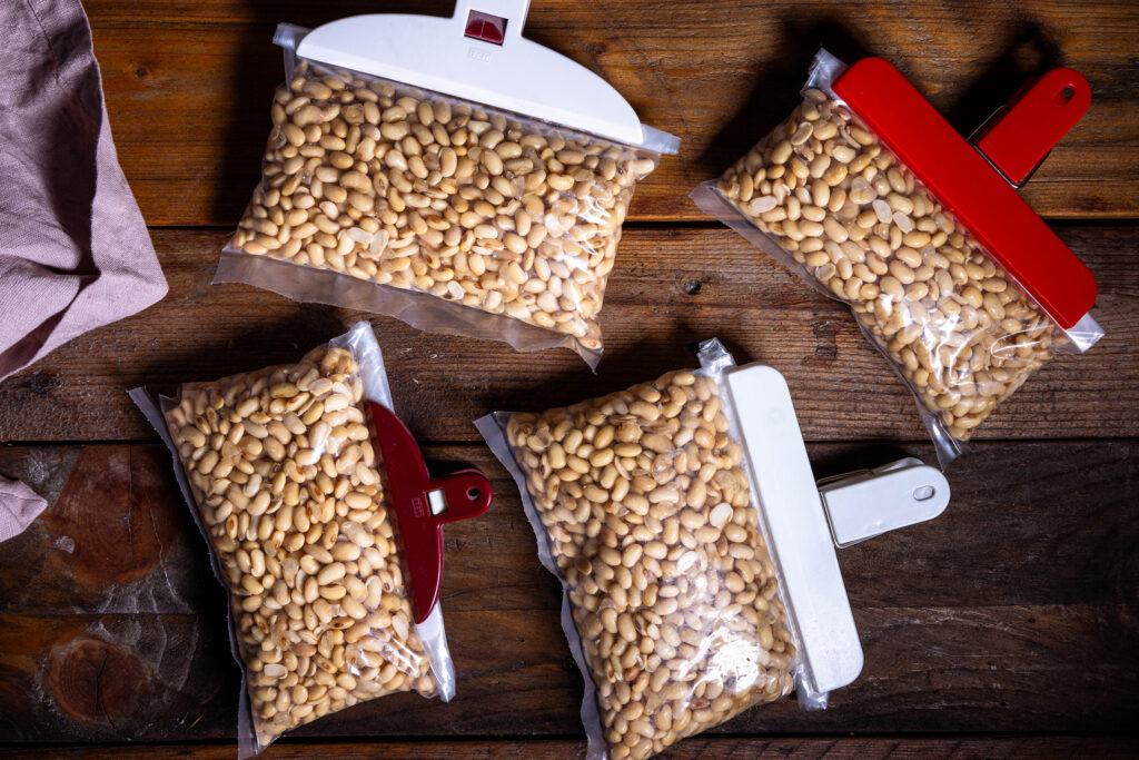 Vier Gefrierbeutel mit Sojabohnen. Mit Clips verschlossen.