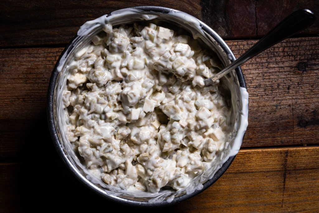 Veganer Fleischsalat wird in einer Schüssel angerührt.