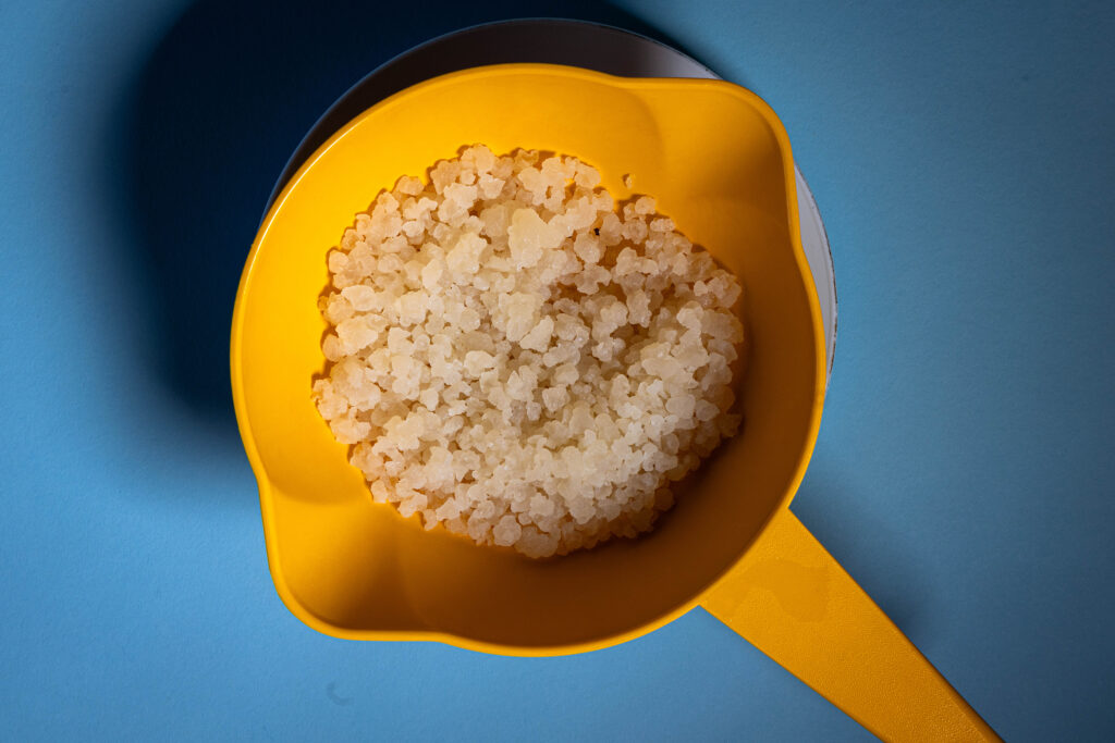 Kefirkristalle in einem orangen Plastiksieb.