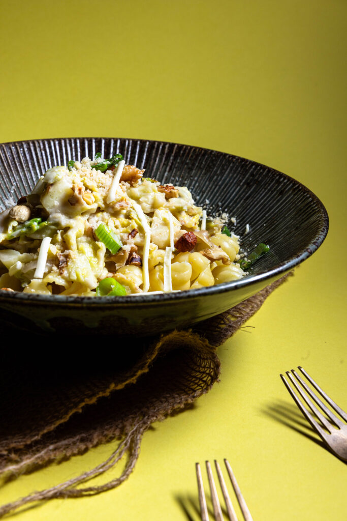 Wirsing-Zitronen-Pasta in einer Bowl, daneben Besteck