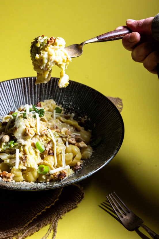 Wirsing-Zitronen-Pasta in einer Bowl. EIne Gabel holt etwas heraus.