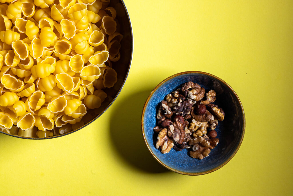 Nüsse und Pasta in Schüsseln.