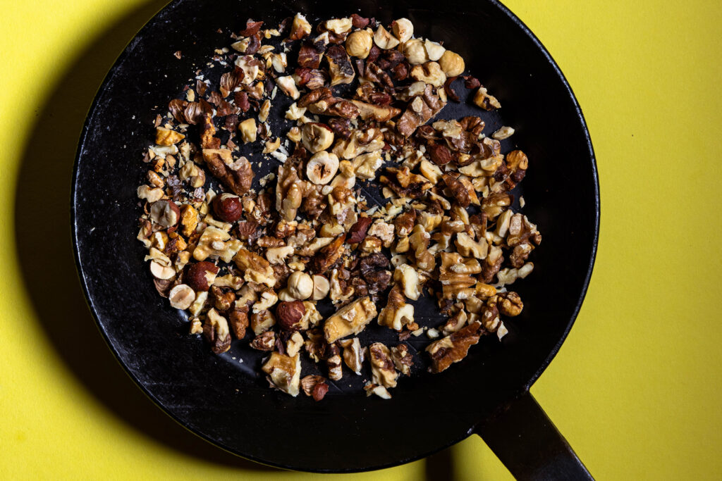 Nüsse werden in einer Pfanne geröstet.